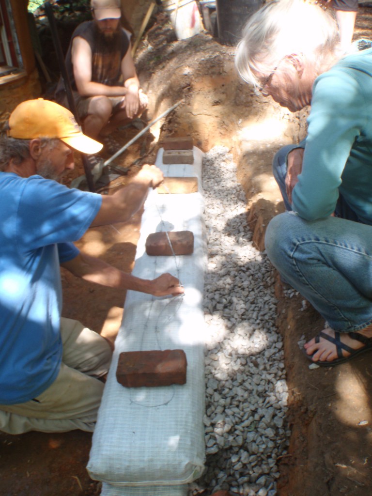 Laying down the barbed wire, which helps hold the earthbags in place.