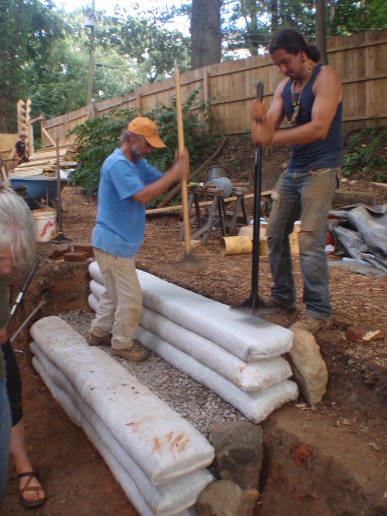 Tamping the earthbags into place.