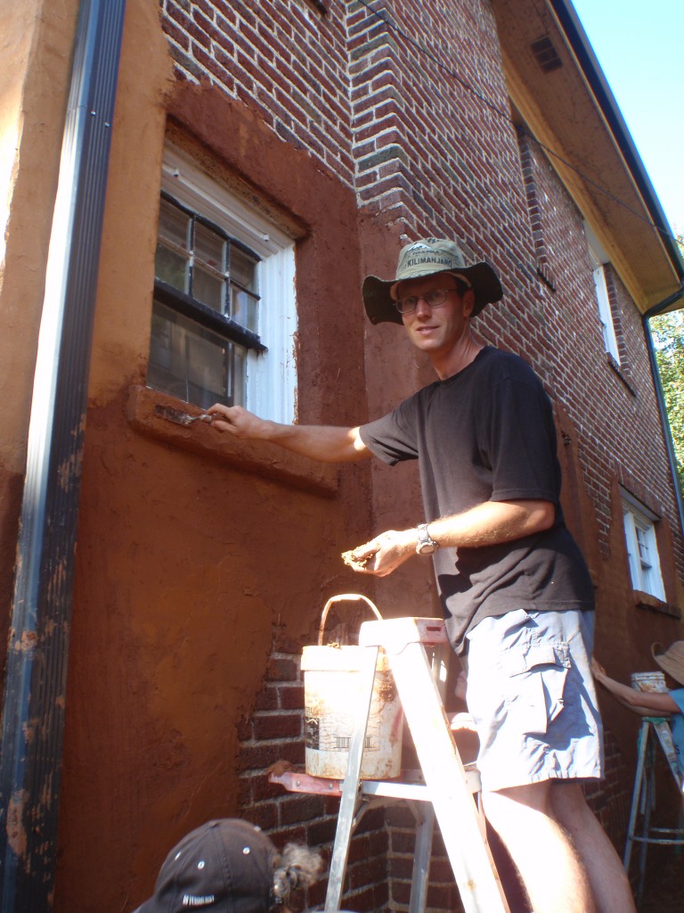 Applying and earthen plaster to a wall.