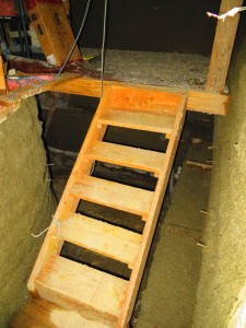 Stairs from entryway to upper level of cistern room. They are hinged so they can be lifted up and allow access to the downstairs area.